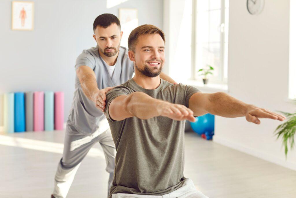 Sportmediziner betreut einen Patienten bei einer Reha-Übung