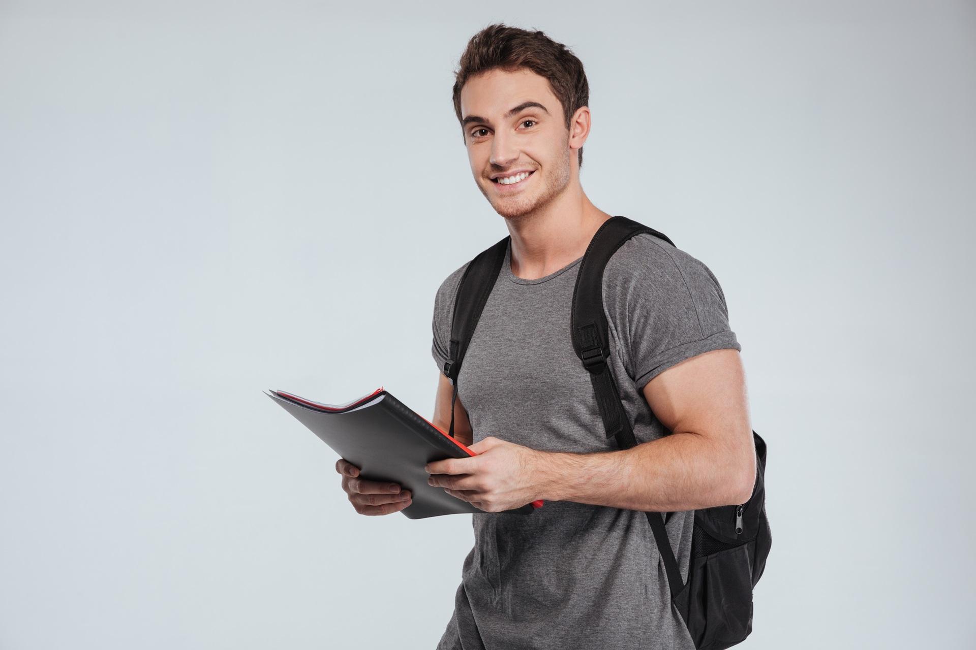 Laechelnder Student mit Rucksack und Unterlagen | Ghostwriter Hausarbeit